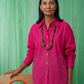 Camisa fucsia por fuera de la falda larga